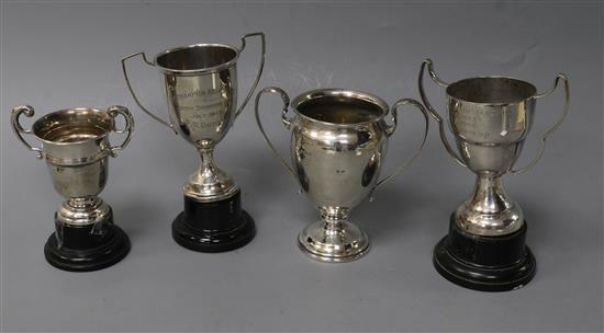 Three small silver two handled trophy cups and a plated trophy cup.